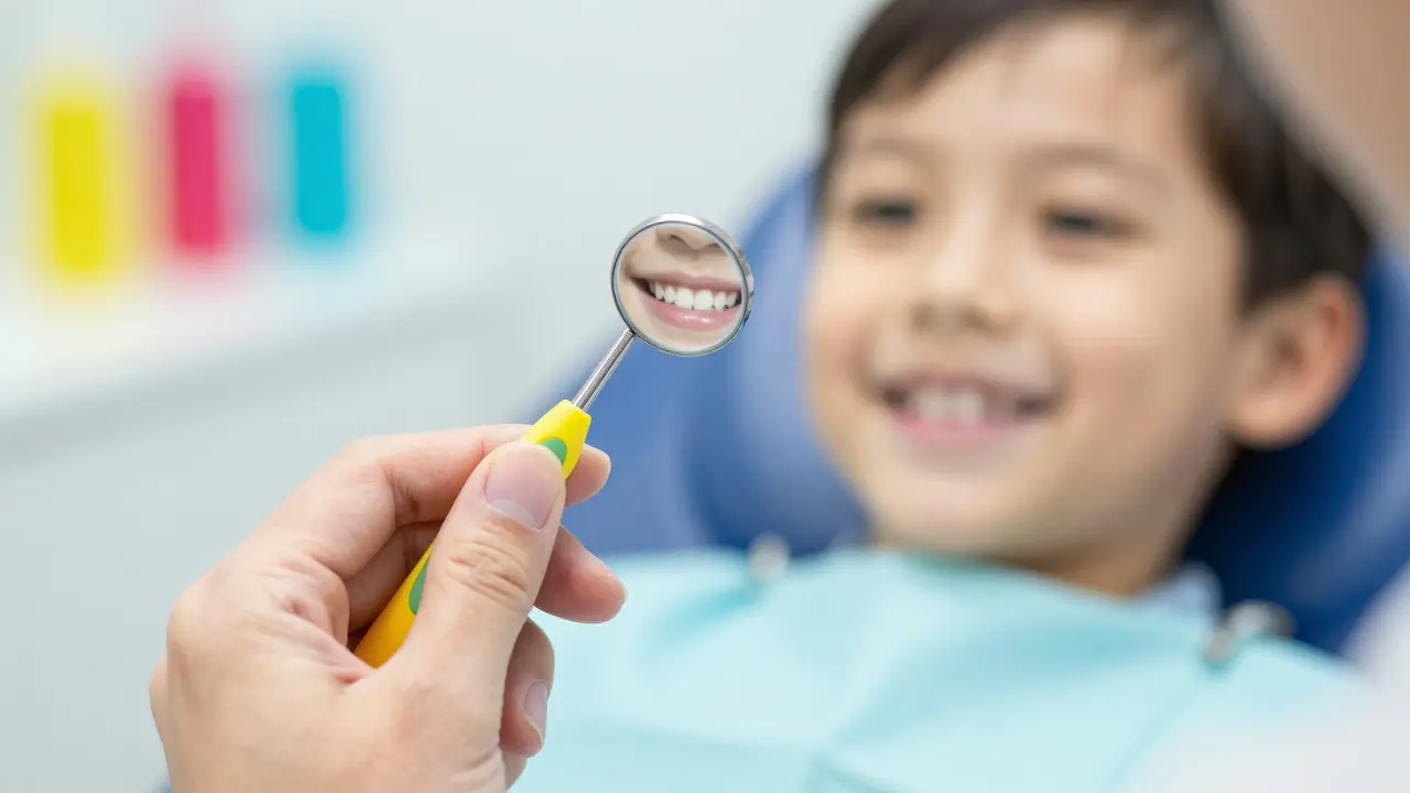 Detail zubařského zrcátka při preventivní prohlídce zdravých dětských zubů.